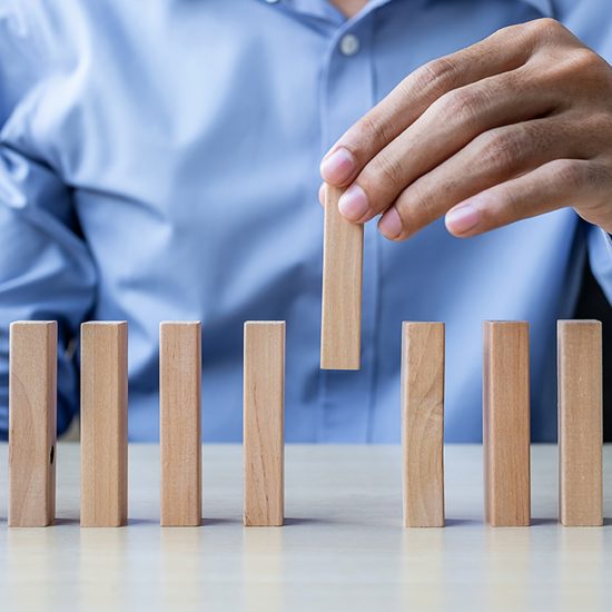 Businessman hand pulling or placing wooden Blocks or Dominoes. Business, Risk Management, Solution and strategy Concepts